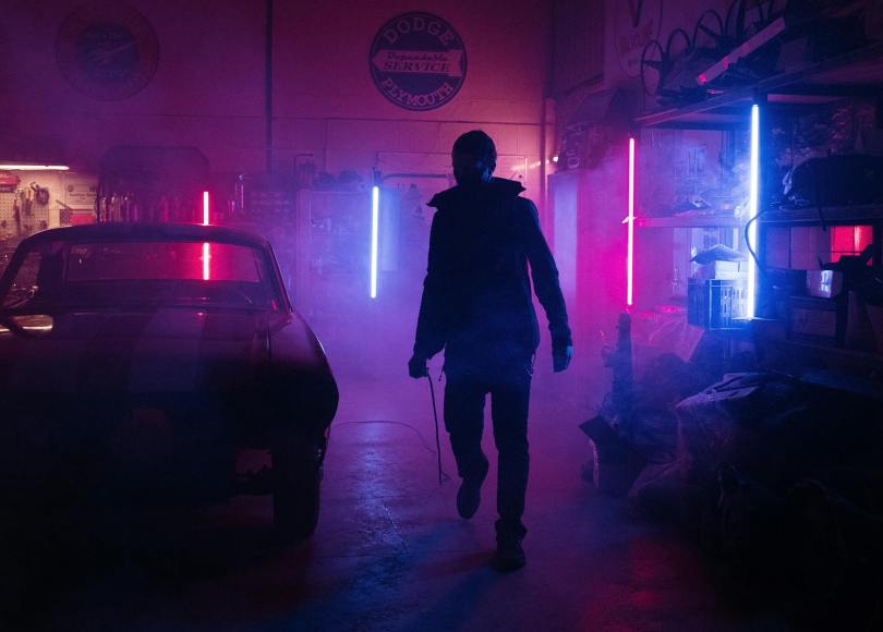 man in black jacket walking on sidewalk during night time